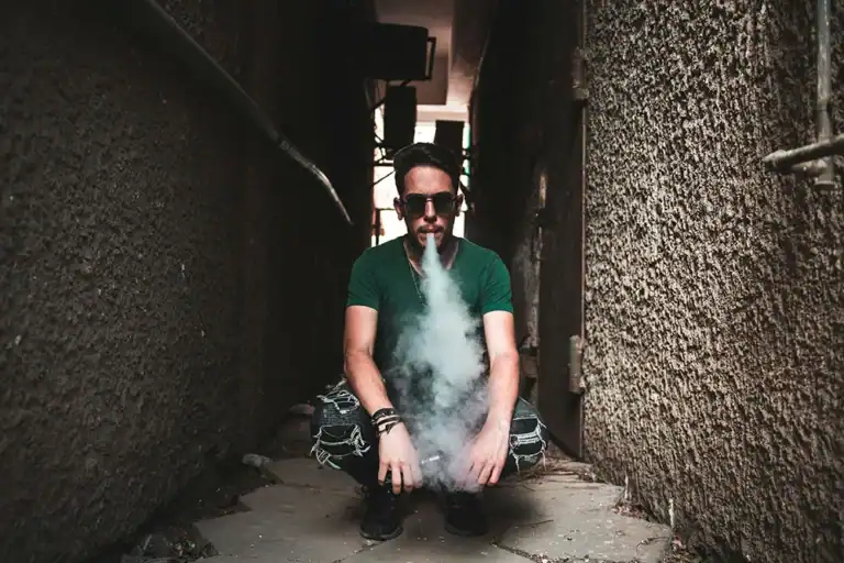 人物在戶外吐出電子煙氣霧的使用情境畫面